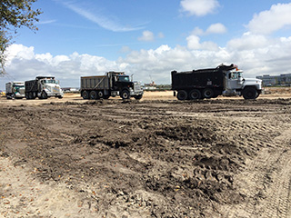 Dump trucks at the future ConRAC site