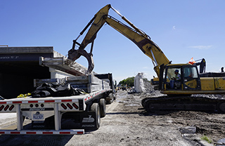 Taxiway J demo - hauling steel beams away