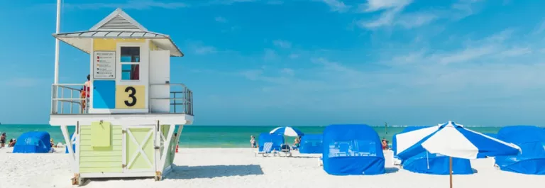 beach lifeguard station with blue beach chairs and beach umbrellas