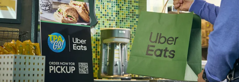 passenger grabbing uber eats bag from restaurant