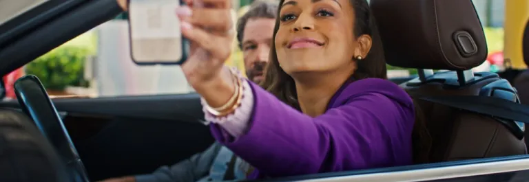 woman in car driving up to parking garage 