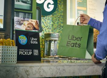 passenger grabbing uber eats bag from restaurant