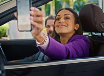 woman in car driving up to parking garage 